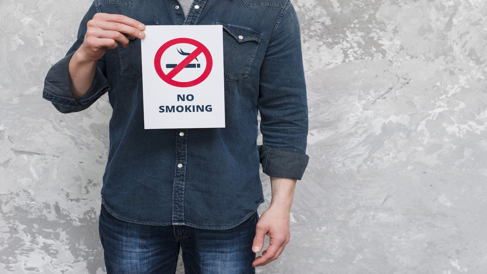 pria-memegang-kertas-tulisan-no-smoking